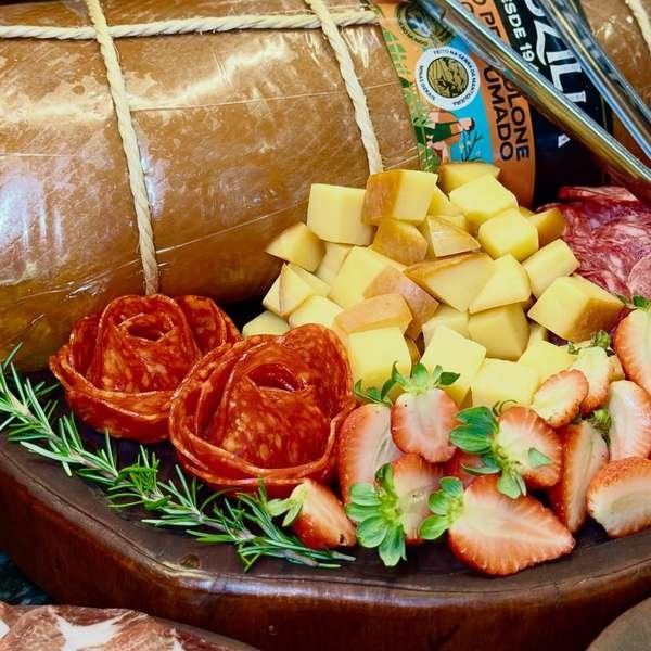 Tábua de frios com salame, queijos e morangos